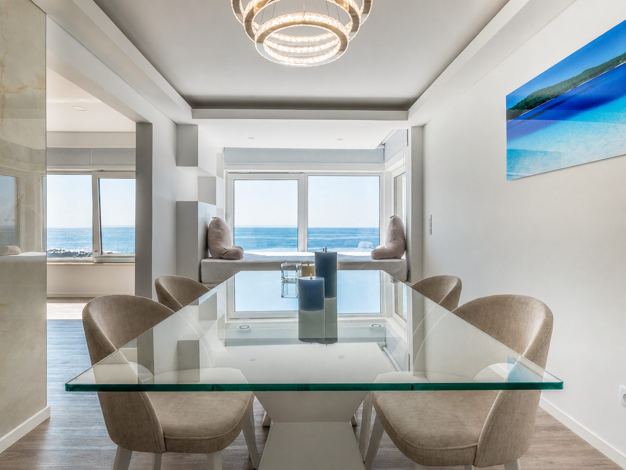 Sala de jantar com mesa de vidro e vista para o mar