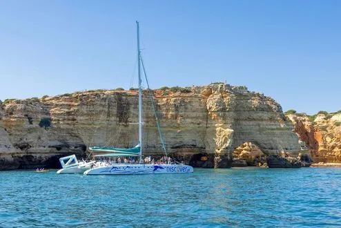 Melhor do Mar sailing catamaran in front of the Algarve cliffs.