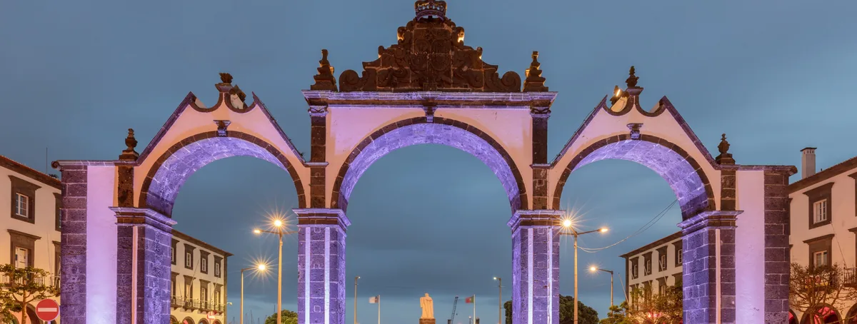 Portas da Cidade in Ponta Delgada illuminated after dark.