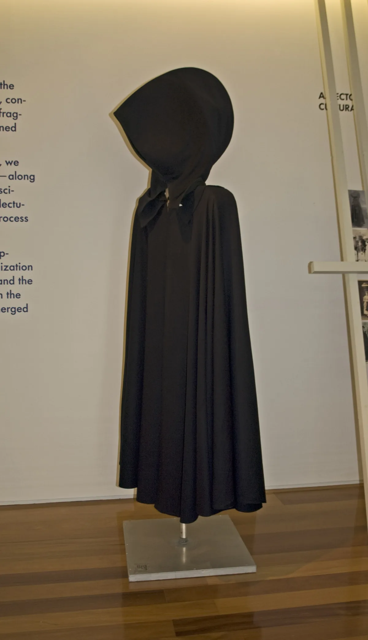 A dark capote e capelo displayed in the Carlos Machado Museum.