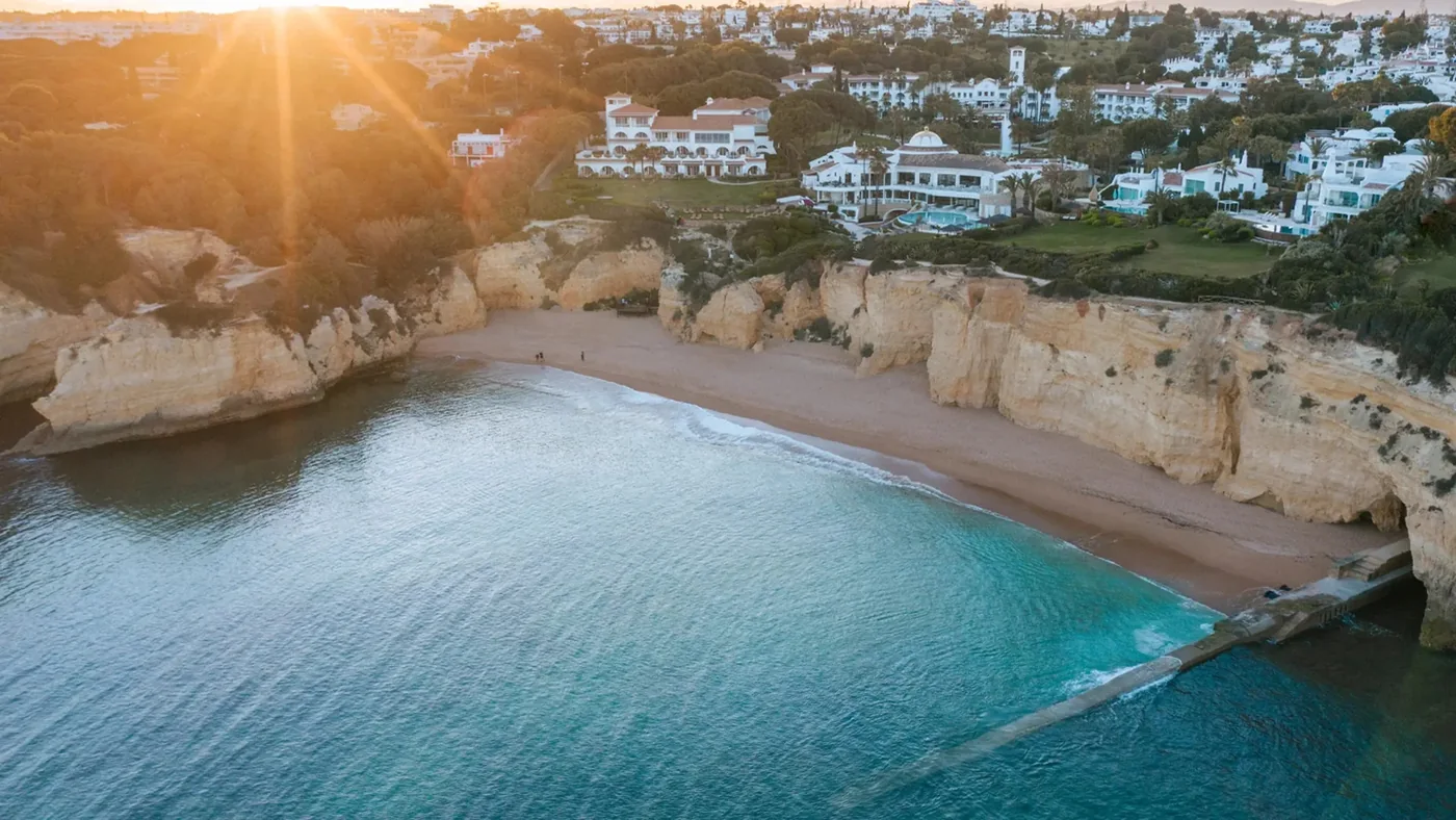 Clifftop coastal resort above a beach and turquoise water in the Algarve.