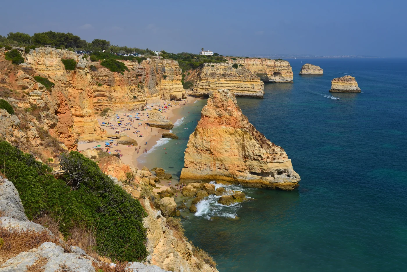 Golden cliffs and sea stacks above the turquoise water at Praia da Marinha.
