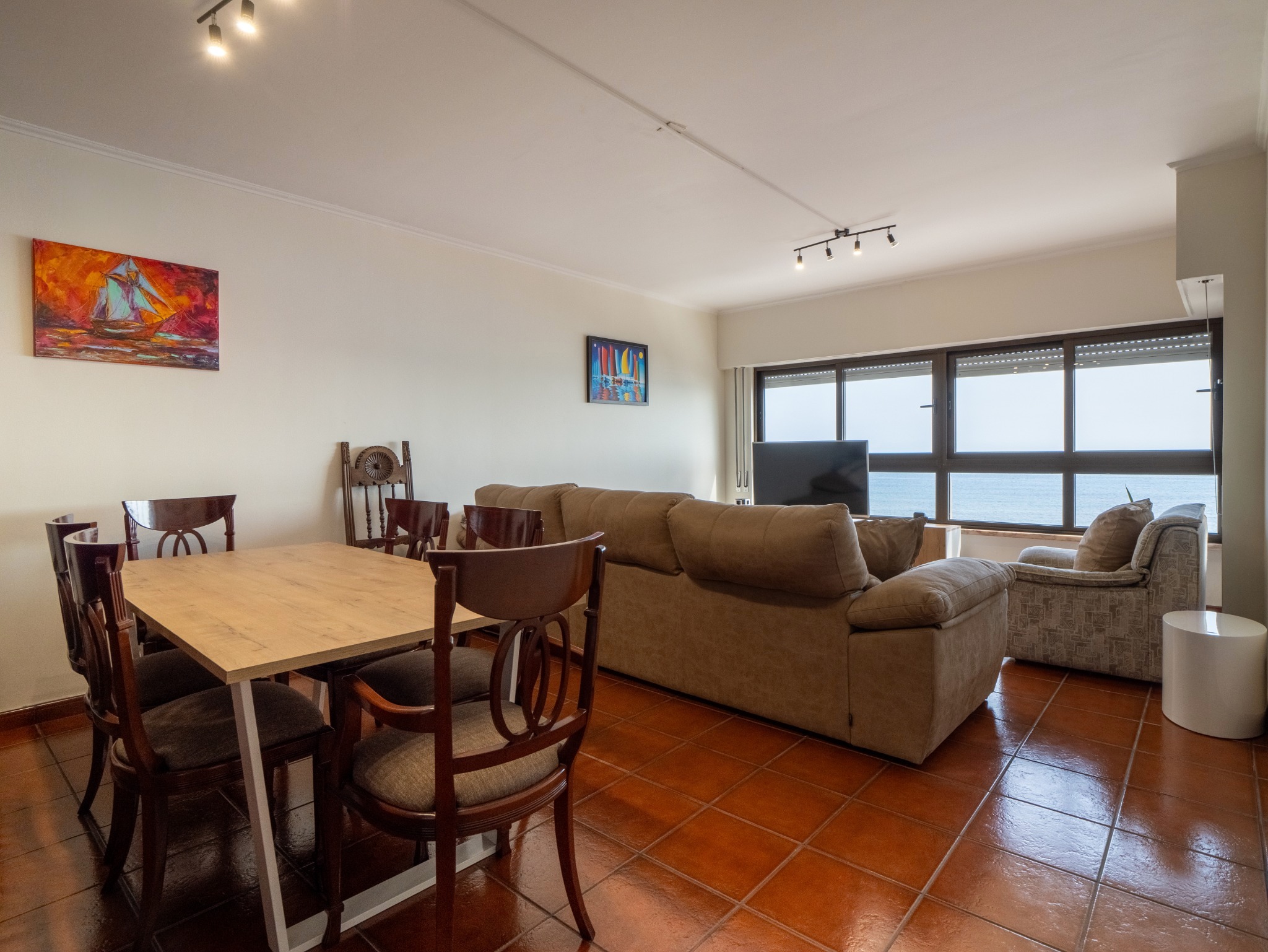 Sala de estar e jantar em plano aberto com vista mar